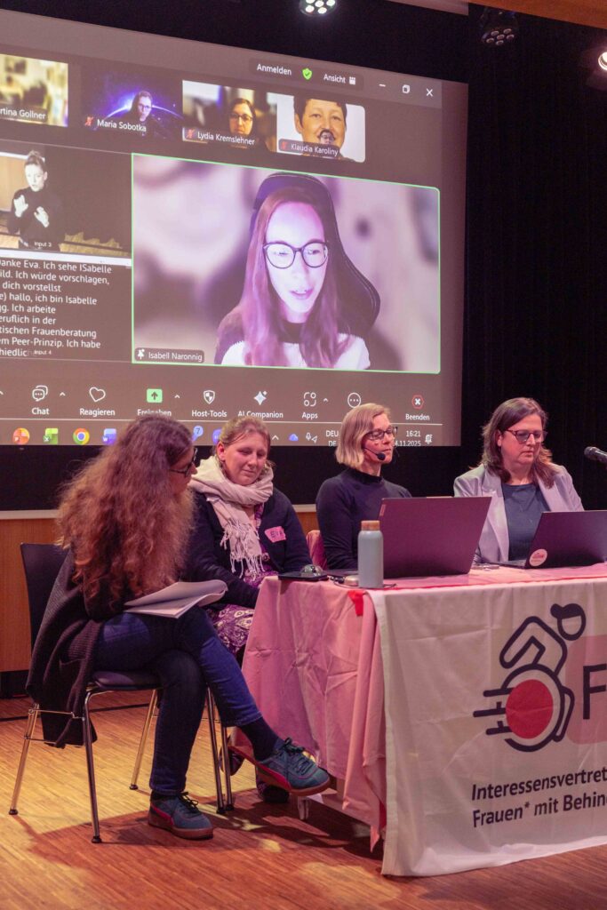 Nina, Eva, Julia und Heidemarie sitzen am Tisch vor den Laptops, im Hintergrund ist Isabell online zugeschalten.