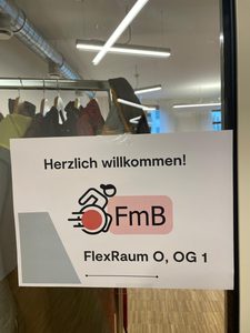 Auf einem Schild wird auf unsere Veranstaltung hingewiesen, es ist der EIngang in den Raum